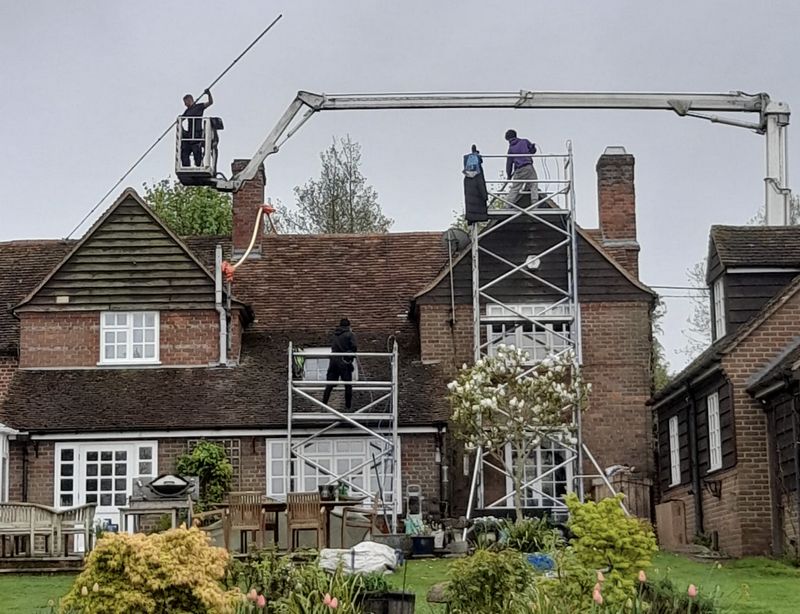 The Roof Moss Cleaners using cherry picker and scaffolding to clean roof safely and professionally in Horsham, West Sussex